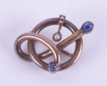 An unusual knotted design brooch (metal not hallmarked or tested) set with two cabochon