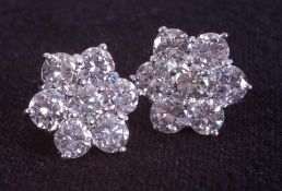 An impressive pair of white gold (not hallmarked or tested) flower cluster earrings set with round