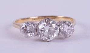 An 18ct yellow & white gold three stone set with round brilliant cut diamonds, the centre diamond is