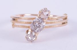 A yellow gold (not hallmarked or tested) antique coil design ring set with two old cushion style cut