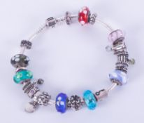 A silver Pandora bracelet with twenty-one charms to include a mixture of Murano glass, silver and