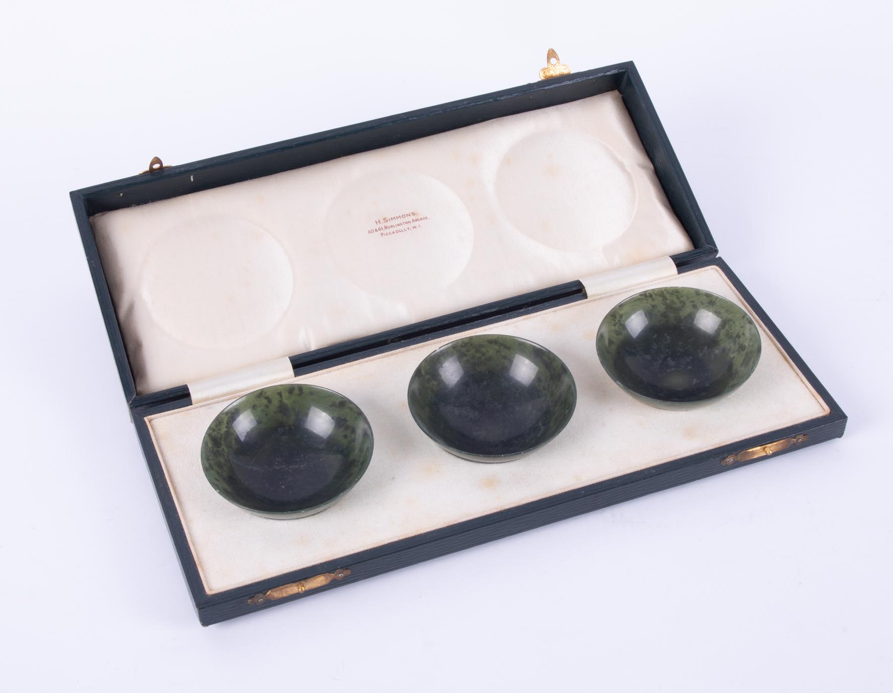 A set of three Chinese spinach jade circular bowls, 6cm diam, retailed by H Simmons,