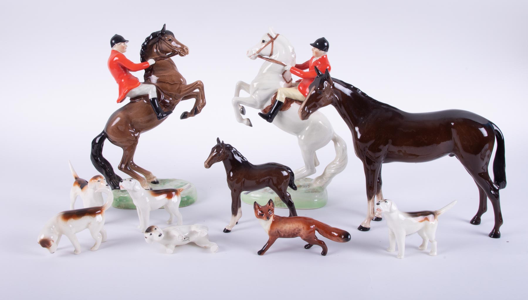 A Beswick hunting group together with two Royal Doulton horses (some damage to the hunting group).