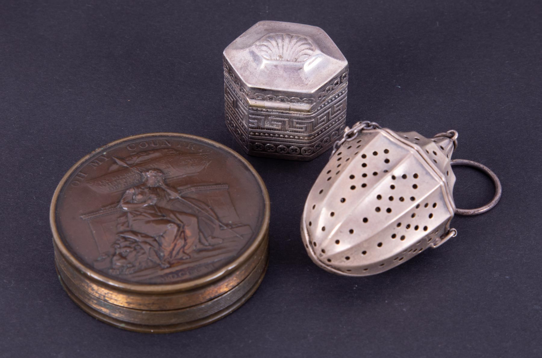 A small white metal pill box, a commemorative circular box William Pitt and a tea strainer.