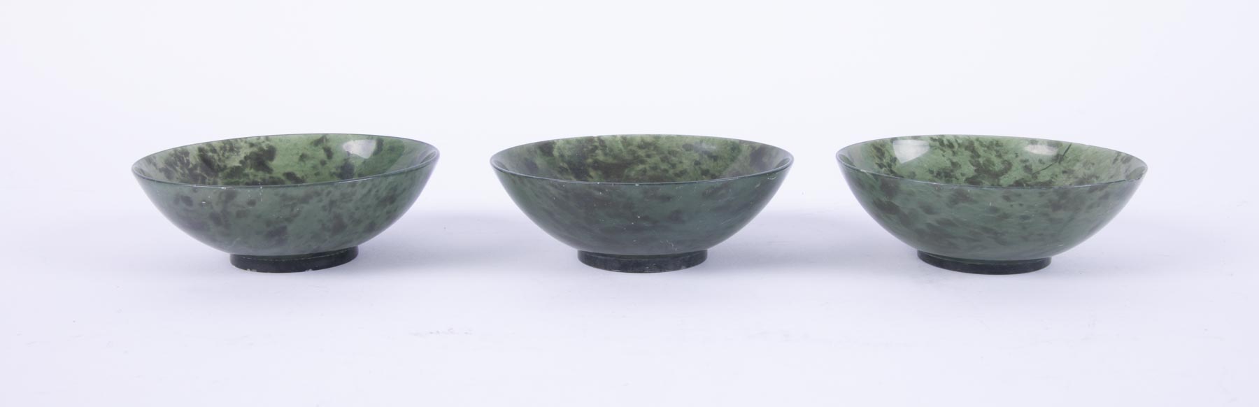 A set of three Chinese spinach jade circular bowls, 6cm diam, retailed by H Simmons, - Image 2 of 2