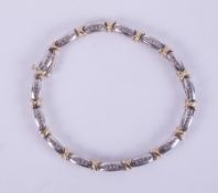 A 9ct white and yellow gold line bracelet set with 0.50 carats of round brilliant cut diamonds, 12.