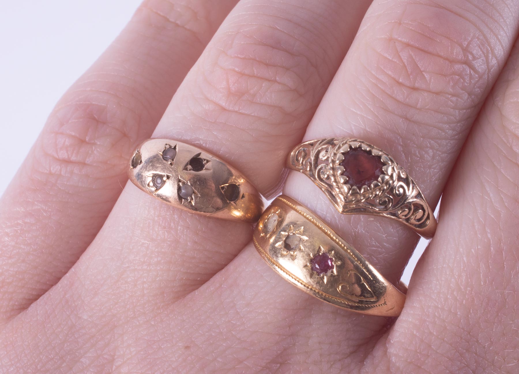 Three rings to include an 18ct yellow gold ring (hallmark has worn away) with red stone