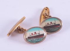 A pair of gold tone cufflinks with a picture of the Queen Victoria steamship.