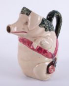 A 19th Century jug in the form of a pig with red sash, height 21cm.