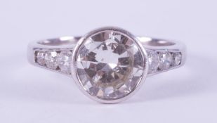 An impressive 18ct white gold ring set with a central rub over set round brilliant cut diamond,