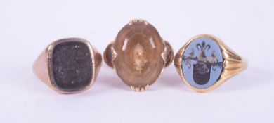 Three rings to include a 9ct yellow gold ring set with an oval cut smokey quartz?