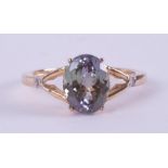 A 9ct yellow gold ring set with an oval cut bi-colour tanzanite, 2.82 carats with a small round