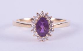An 18ct yellow gold cluster style ring set with a central oval cut amethyst, approx. 0.43 carats,