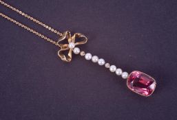 A 15ct yellow gold pendant with a bow design at the top and a line of seed pearls leading down to