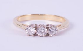 An 18ct yellow gold & platinum three stone ring set with round brilliant cut diamonds, total