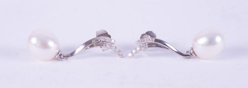 A pair of 9ct white gold drop earrings set with an oval freshwater pearl, measuring approx. 9.5mm