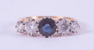 An 18ct yellow gold & platinum five stone ring set centrally with a round cut sapphire, approx. 0.54