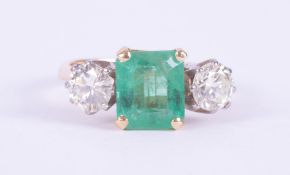 An 18ct yellow & white gold ring set with a central emerald cut emerald, approx. 1.70