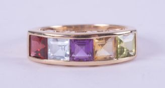 A 9ct yellow gold multi-stone ring set with a square cut garnet, blue topaz, amethyst, citrine &