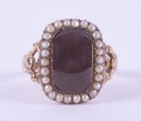 An antique 9ct yellow gold ring set with a cabochon cut rectangular garnet, measuring approx. 1.