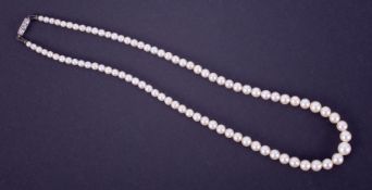 A graduated string of cultured pearls with a platinum clasp set with three round cut diamonds, total