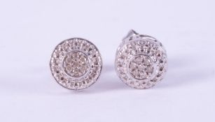 A pair of 9ct white gold round cluster earrings set with small round brilliant cut diamonds in an