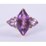 A 9ct yellow gold ring set with a central marquise cut amethyst, approx. 3.38 carats, with a