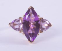 A 9ct yellow gold ring set with a central marquise cut amethyst, approx. 3.38 carats, with a