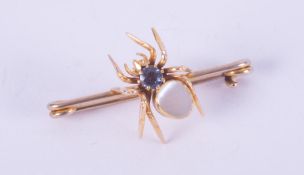 An antique yellow gold (not hallmarked or tested) spider brooch set with mother of pearl and a round