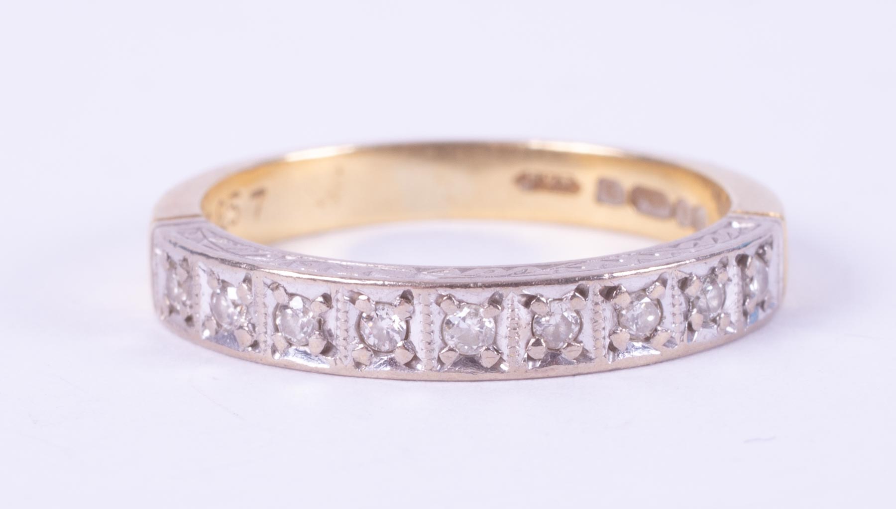 An 18ct yellow gold & platinum half eternity ring set with nine small round diamonds, total
