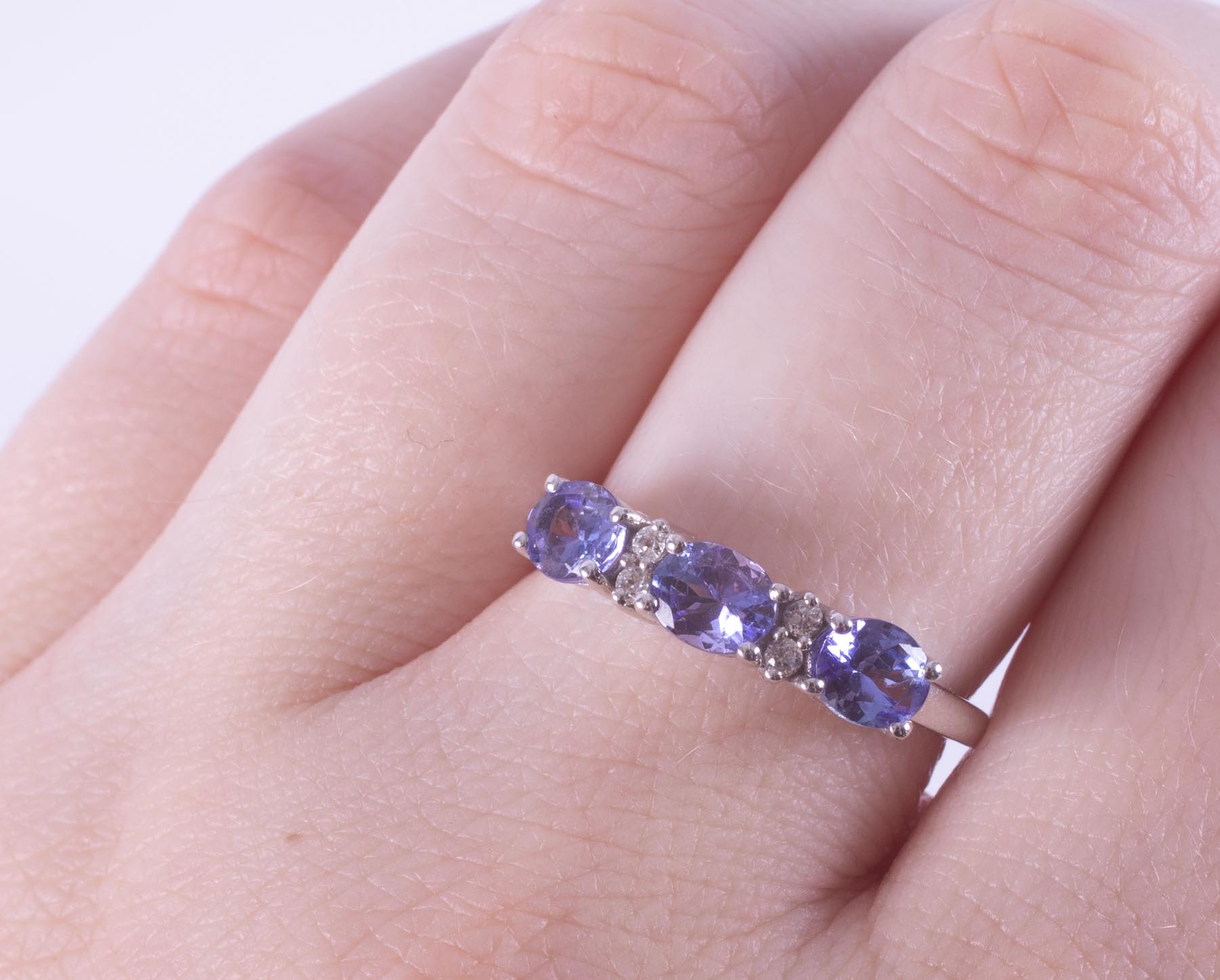 A 9ct white gold ring set with three oval cut tanzanite's interspaced with four small round cut - Image 2 of 2