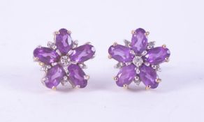 A pair of 9ct white & yellow gold flower design earrings set with oval cut amethyst, total weight