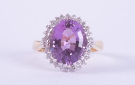 An 18ct yellow & white gold cluster ring set with a central oval cut amethyst, approx. 4.30