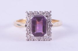 An 18ct yellow & white gold ring set with a rectangular cut amethyst, approx. 1.17 carats,