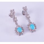 A pair of 18ct white gold drop earrings in a flower & cluster design set with cabochon cut