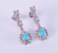 A pair of 18ct white gold drop earrings in a flower & cluster design set with cabochon cut