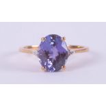 A 9ct yellow gold ring set with a central oval cut AAA tanzanite, 2.54 carats with a small round