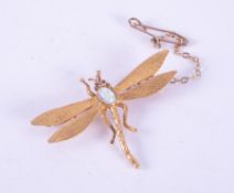 An antique 15ct yellow gold dragonfly brooch set with an oval cabochon cut opal measuring approx.