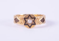 An ornate 18ct yellow gold mourning ring with a central circular panel with black