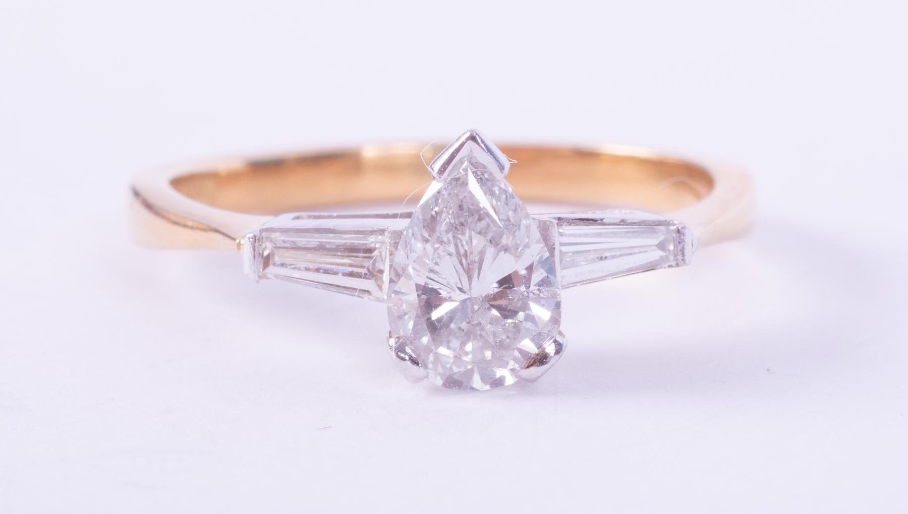 An 18ct yellow & white gold ring set with a central pear shaped diamond, approx. 0.75