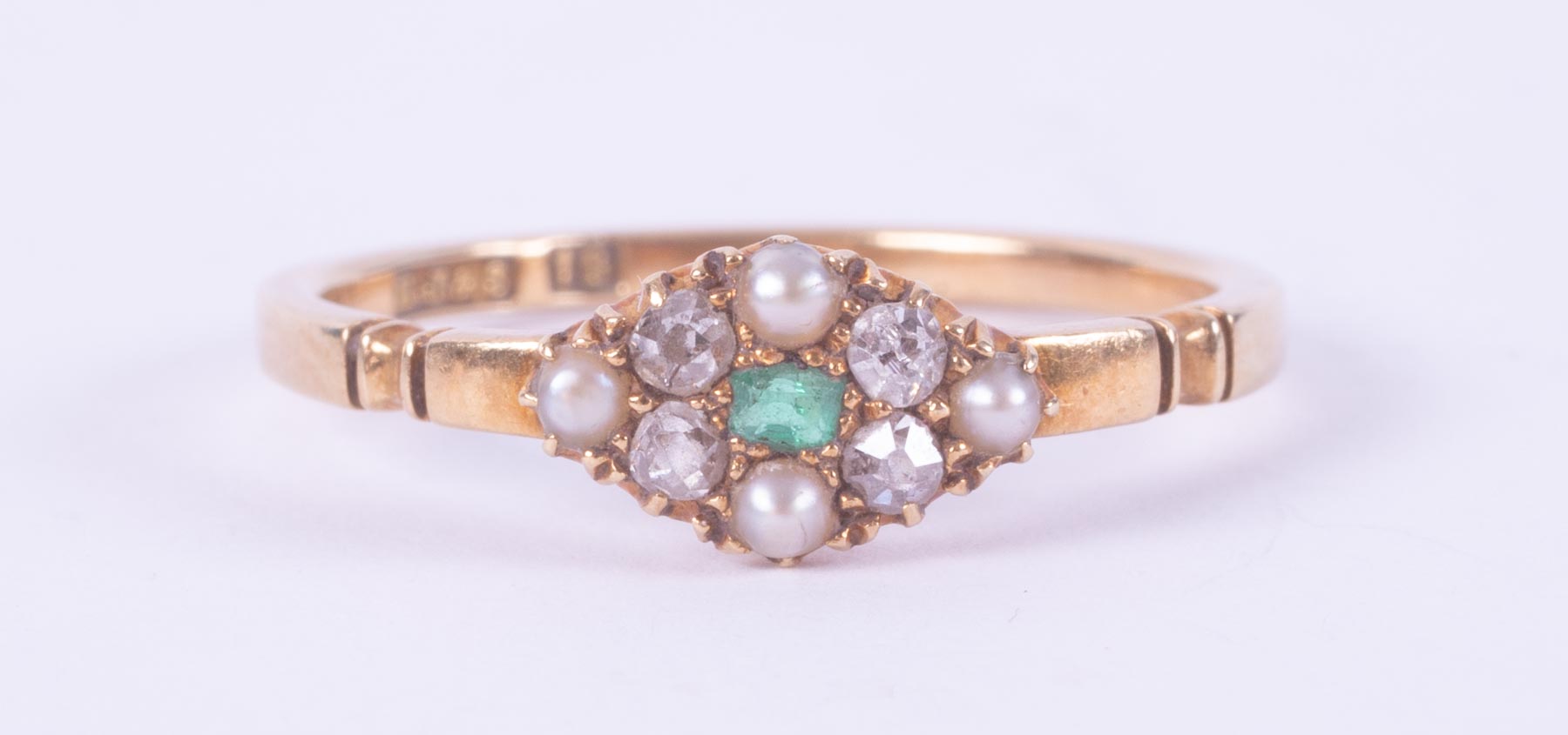 An antique 18ct yellow gold ring set with a central emerald cut emerald, surrounded by four small