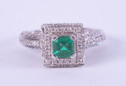 A 14ct white gold fancy design ring set with a square cut emerald, approx. 0.50 carats surrounded by