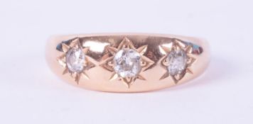 An 18ct yellow gold gypsy style ring set with three old round cut diamonds, total diamond weight