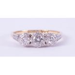 An 18ct yellow gold & platinum three stone ring set with older round cut diamonds in an illusion