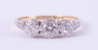 An 18ct yellow gold & platinum three stone ring set with older round cut diamonds in an illusion