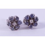 A pair of 18ct white gold flower studs set with small round cut sapphires & a small central diamond,