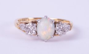 An 18ct yellow gold & platinum three stone ring set with a central oval cabochon cut opal