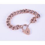 A 9ct rose gold curb link bracelet with flower engraved heart padlock, and pattern engraved links,
