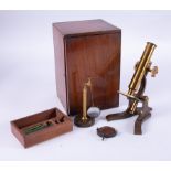 A vintage brass table microscope with original box.