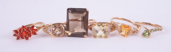 A mixed bag of six 9ct yellow gold gem set rings to include smokey quartz, lemon quartz, peridot,